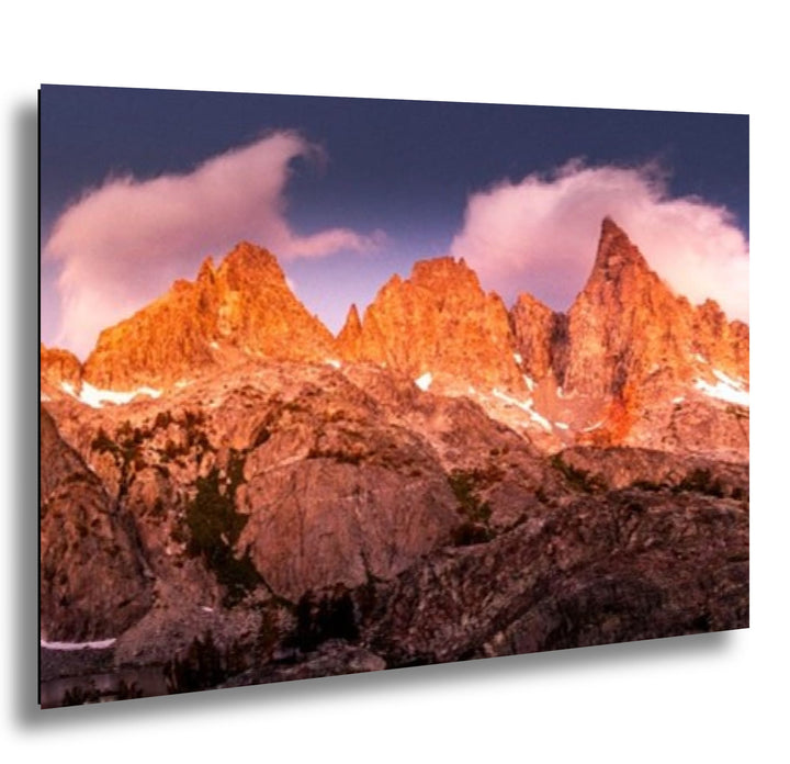 Dramatic alpine mountain peaks with pink clouds and golden sunset sky landscape photography.