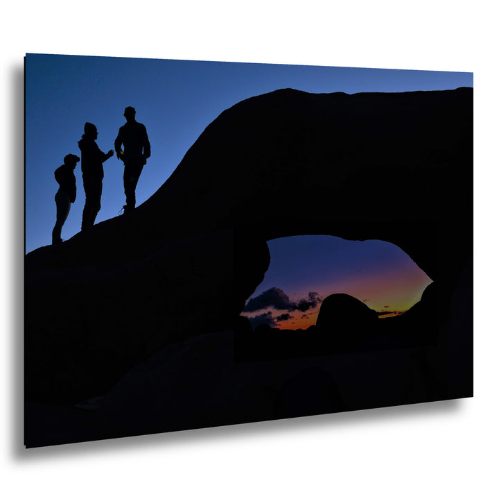 Silhouette of Arch Rock with silhoutte of people on top in Joshua Tree National Park