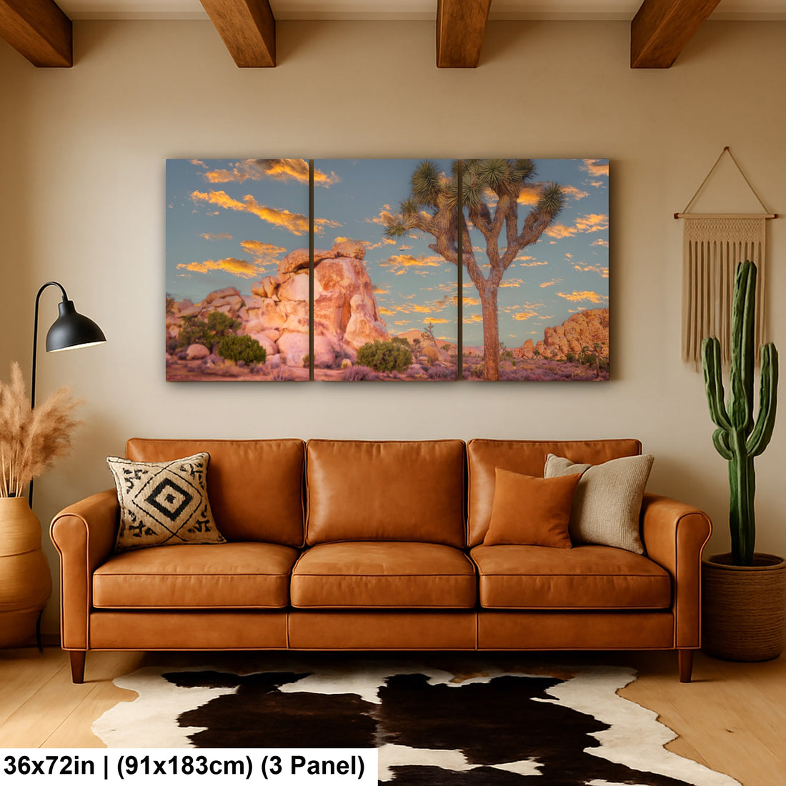 Joshua Tree sunset landscape canvas art above wooden console table with cactus, pampas grass, and cowboy hat in southwestern home decor.