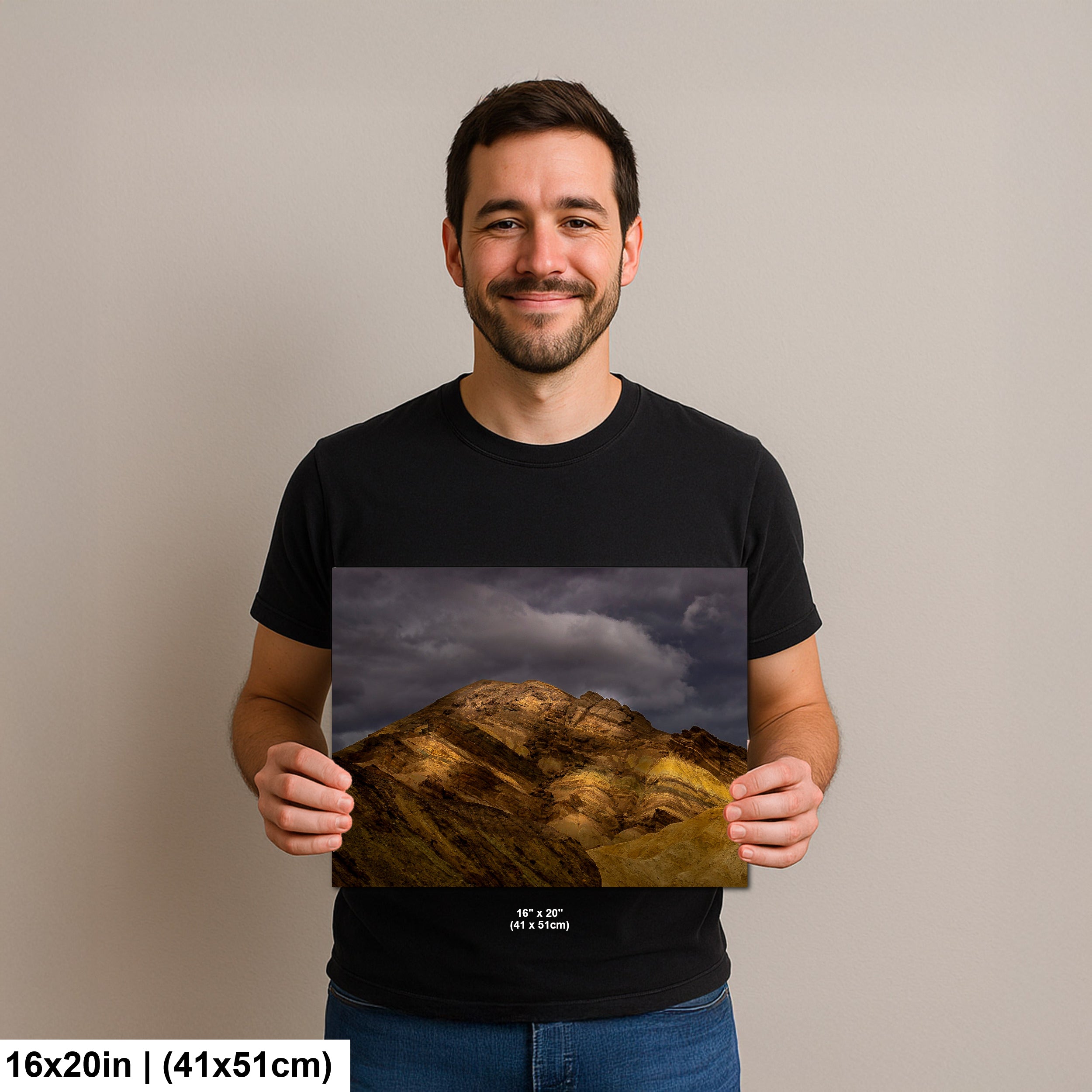 Photographer holding 16x20 inch Death Valley golden hills print on neutral background.