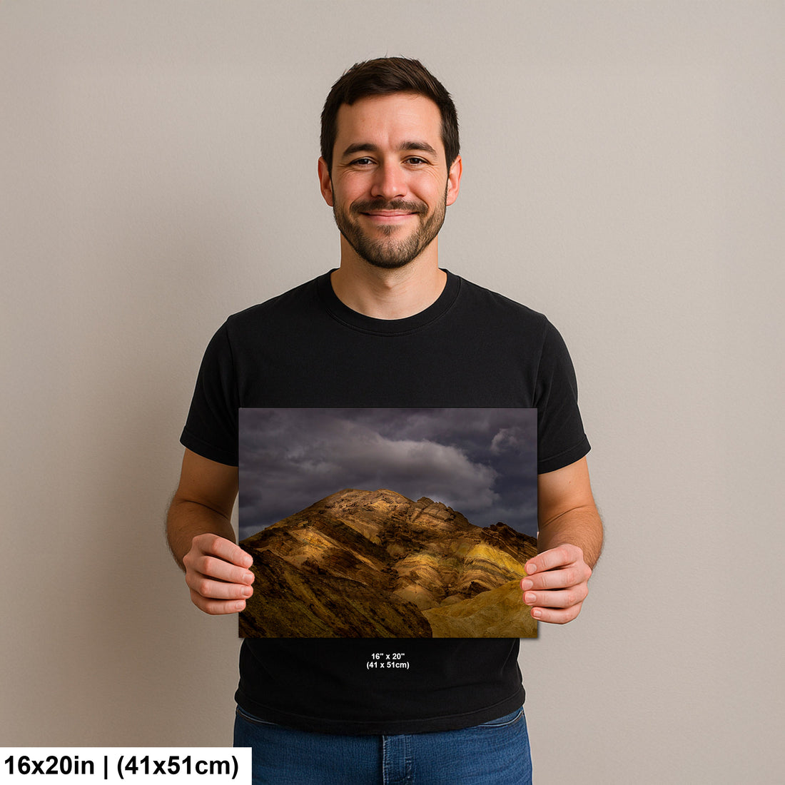 Photographer holding 16x20 inch Death Valley golden hills print on neutral background.