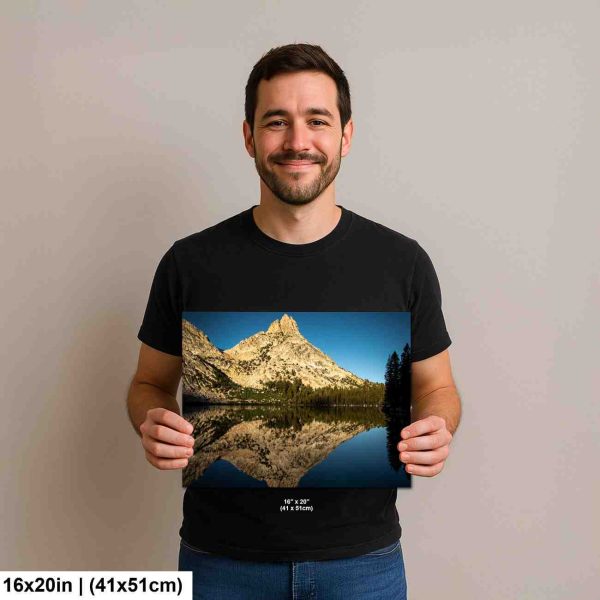 Man holding mountain lake reflection with alpine peak and forest landscape photography print.