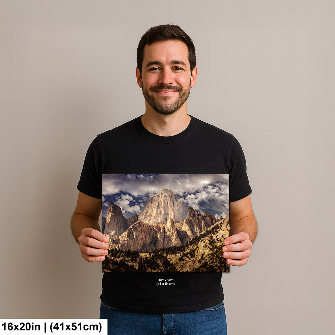 Man holding Yosemite El Capitan granite monolith and valley landscape photography print with cloudy sky.