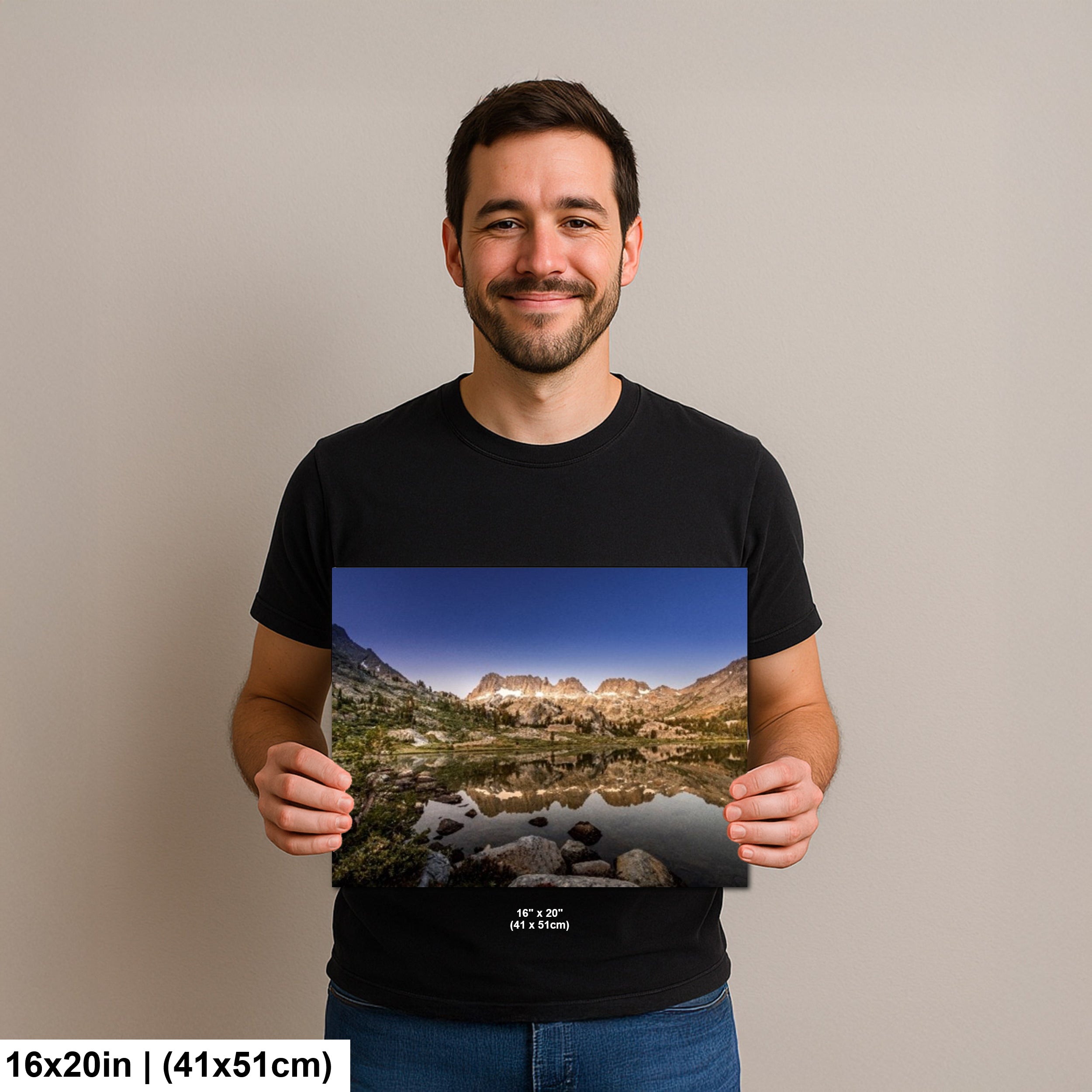 Man holding mountain lake reflection with granite peaks and alpine landscape photography print.