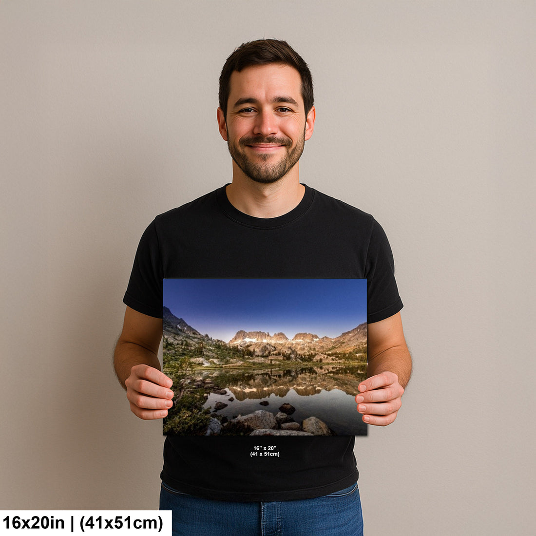 Man holding mountain lake reflection with granite peaks and alpine landscape photography print.