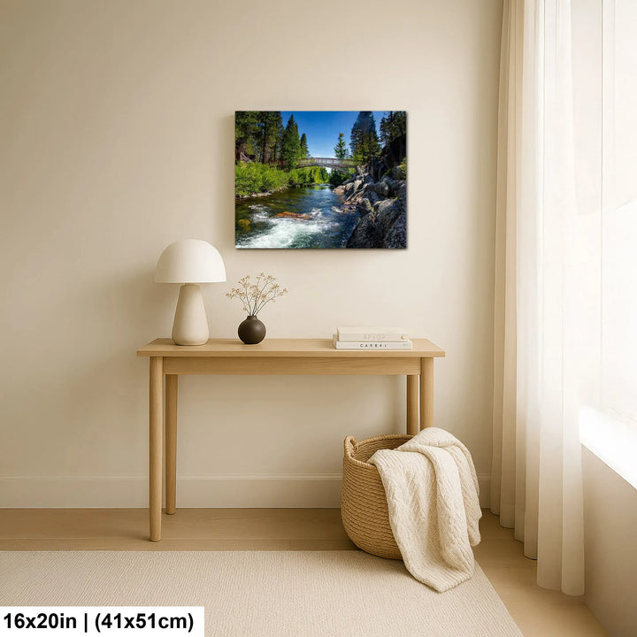 Alpine river and forest landscape canvas above wooden console table in minimalist home decor.